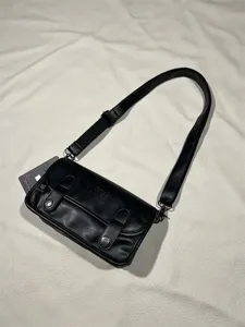 Detailed view of the black vintage style retro crossbody shoulder bag with flap and metal hardware.