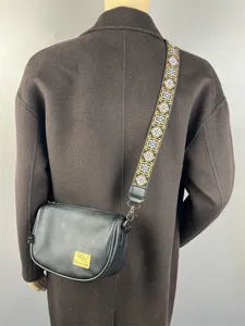 Black PU leather cross-body bag with wide patterned strap, stylish crescent casual shoulder bag.