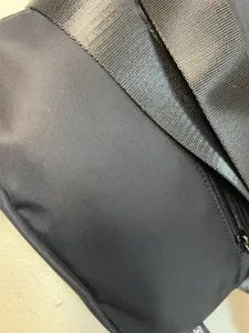 Detail shot of black nylon cross body bag showing premium fabric texture and sturdy strap.