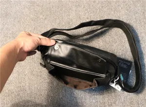 Black leather men crossbody bag detail showing front pocket and interior lining.