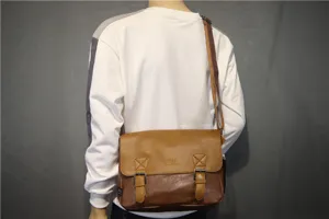 Detailed view of retro brown messenger bag, casual crossbody design with dual buckle straps.