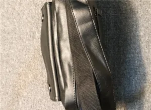 Detailed view of the side and strap structure of the black mens casual crossbody bag.