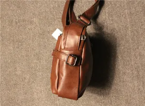 Side detail view of brown faux leather men retro messenger bag with metal buckle strap.