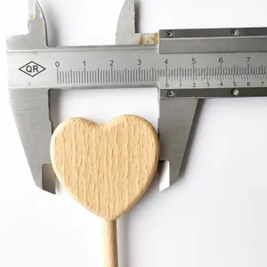 Close-up detail of unpainted beech wood heart wand prop, natural wood grain display.