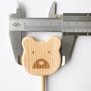 Detailed view of unpainted wooden bear head fairy wand, natural beech photo prop toy.