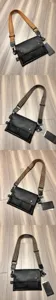 Detail view of black leather crossbody bag featuring patterned strap and branded hangtag.