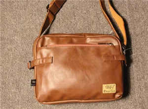 Brown leather shoulder bag detail showing front zipper pocket and brand logo label.