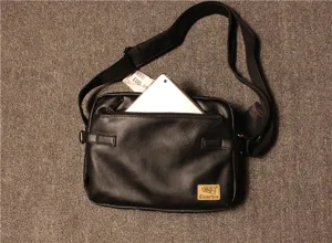 Detailed view of black PU leather messenger bag with front zipper pocket and adjustable strap.