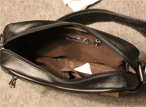Black leather messenger bag interior detail showing durable lining, zipper and pocket.