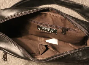 Detail view of men casual shoulder bag interior with zipper pocket and brown lining.