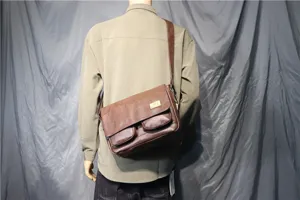 Detailed view of brown vintage leather messenger bag, casual crossbody satchel for men.