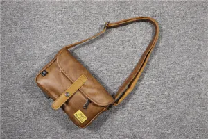 Brown vintage crossbody bag detail, compact leather shoulder bag with magnetic buckle.