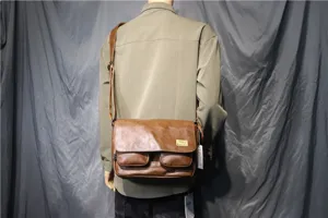 Brown leather messenger bag for men, vintage retro shoulder bag with flap and front pockets.