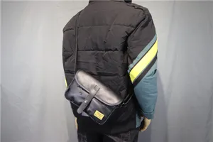 Detail view of the black leather crossbody bag worn by model, showing size and fit clearly.