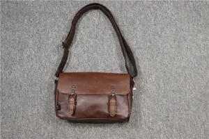 Detail view of the vintage dark brown leather men's shoulder bag with dual buckle flap design.