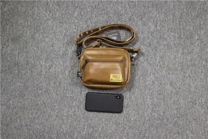 Vue détaillée du sac bandoulière décontracté en cuir marron pour homme avec une poche avant.