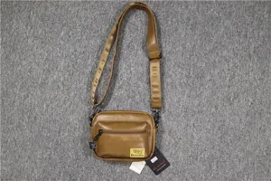 Vue détaillée du sac bandoulière en cuir marron avec une poche zippée avant et sangle.
