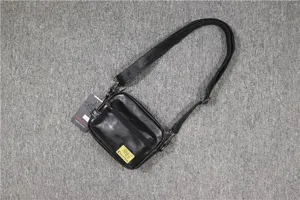 Petit sac bandoulière noir pour homme en cuir PU avec une poche zippée et sangle réglable.