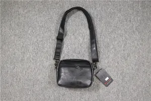 Vue rapprochée du sac bandoulière homme noir avec poche zippée et sangle réglable.
