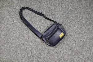 Sac bandoulière décontracté pour homme en bleu foncé avec poche zippée et sangle réglable.