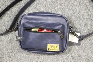 Détail de sac bandoulière homme, cuir PU bleu foncé, poche frontale zippée pratique.
