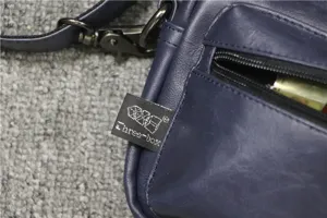 Sac bandoulière bleu casual homme vue détaillée poche zippée avec étiquette de marque similicuir.