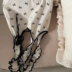 Close-up detail of sweet polka dot canvas bag with black bow print and ruffled drawstring straps.