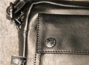 Close-up detail of black PU leather men messenger bag front pocket and metal snap button.