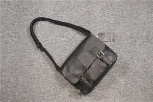 Detail view of black vintage leather messenger bag, showing buckle, correa and texture.