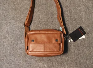 Close-up detail shot of brown leather men casual crossbody bag with front pocket and strap.
