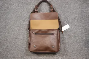 Detailed view of the brown retro messenger bag showing interior pocket and metal hardware structure.