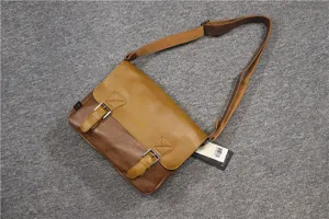 Detailed close-up view of the vintage brown messenger bag showing dual buckle straps and leather.