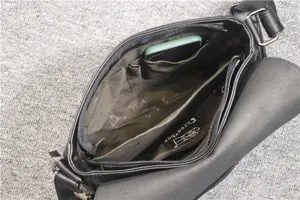 Interior detail view of black leather messenger bag with multiple pockets and zipper.