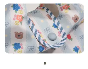 Detalle de bolso de mano mini de lona con oso tierno, flores y estampado de lazos.