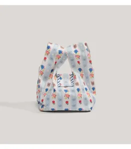 Detalle de primer plano de mini bolso de lona a rayas con estampado de flores y osos.