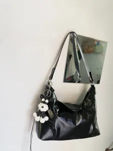 Black patent leather hobo shoulder bag with cute puppy charm, minimal daily commuter style.