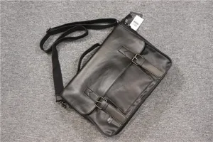 Black leather messenger bag detail, business casual flap briefcase with dual buckle straps.
