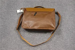 Brown leather men messenger bag detail view with shoulder strap and zipper pocket.
