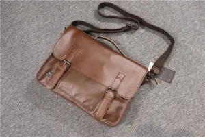 Detailed view of the brown leather messenger bag featuring dual buckles and handle.