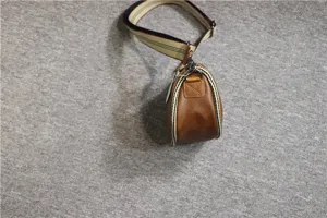 Men vintage brown leather saddle bag casual cross-body dumpling bag with striped shoulder strap.