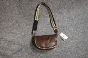 Detail view of retro men brown leather saddle bag with striped strap for daily use.