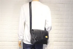 Casual black soft leather messenger bag for men and women, stylish crossbody shoulder bag.