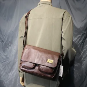 Vintage brown leather messenger bag for men, stylish crossbody shoulder bag with dual front pockets.