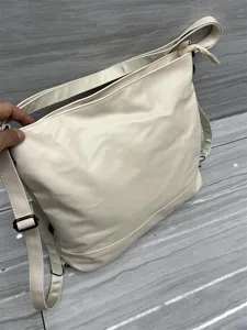 Sac à dos et bandoulière multifonctionnel, grand sac cabas en cuir souple beige pour usage quotidien.