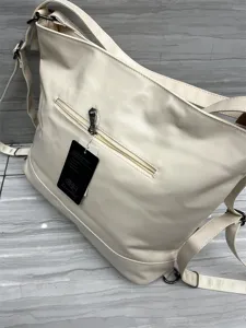 Vue détaillée du sac à dos et sac à bandoulière élégant en cuir synthétique avec poche zippée.