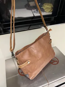 Sac bandoulière homme en cuir souple marron, détail texture sac épaule vintage casual.