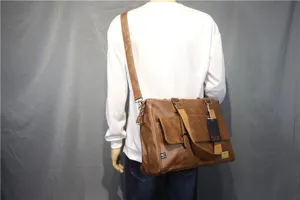 Detail view of men's brown faux leather messenger bag showing shoulder strap and front tag.
