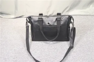 Black faux leather business travel shoulder bag detail shot showcasing handle and strap design.