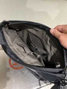 Vue détaillée de l'intérieur du sac à bandoulière souple noir pour homme avec poches.