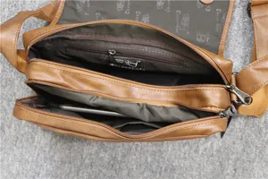 Detailed view of the brown PU leather messenger bag interior compartments and zipper pockets.